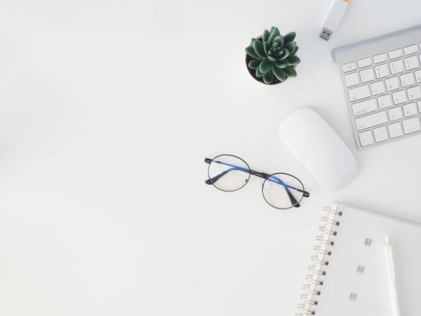 istock top view of office desk table with notebook, plastic plant, digital camera and keyboard on white background, graphic designer, Creative Designer concept. 1176297353