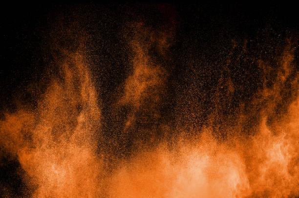 istock Orange powder explosion on black background. Orange color dust splash. 1176298629