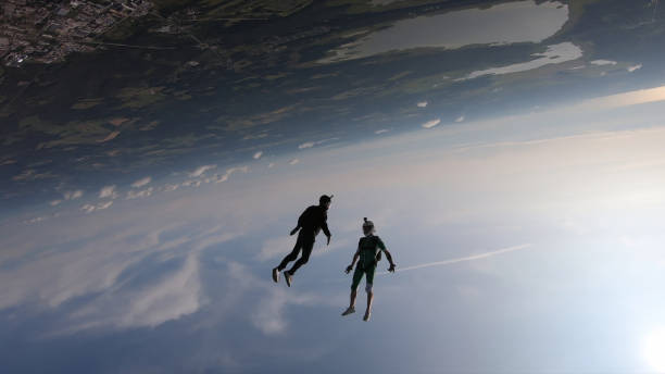 istock Skydivers fall through clear skies, in aerial flight 1176299852