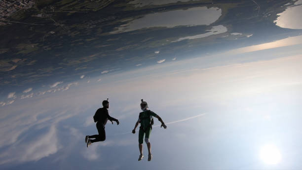 istock Skydivers fall through clear skies, in aerial flight 1176299860
