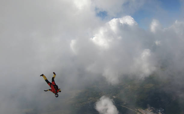 istock Skydiver falls through clear skies, in aerial flight 1176300017