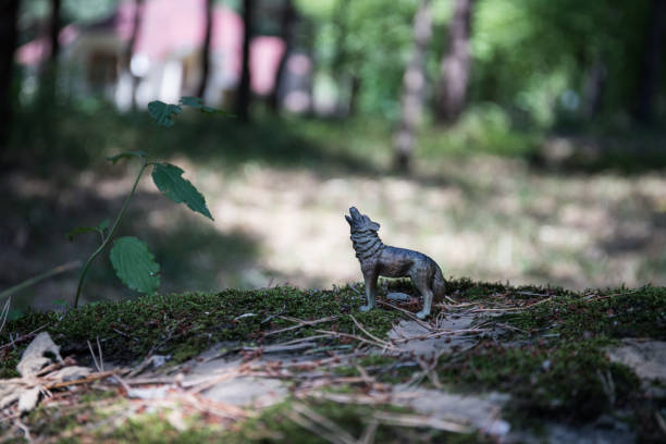 istock Howling wolf in the forest. Mini wolf figure standing on the forest ground. 1176300066