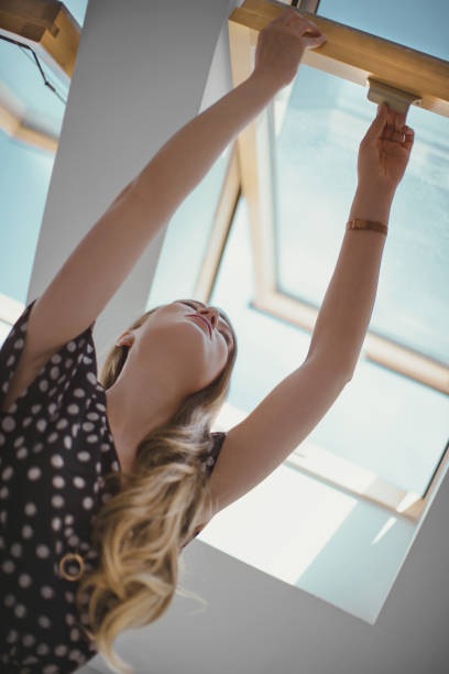 istock Young woman opening window. 1176300402