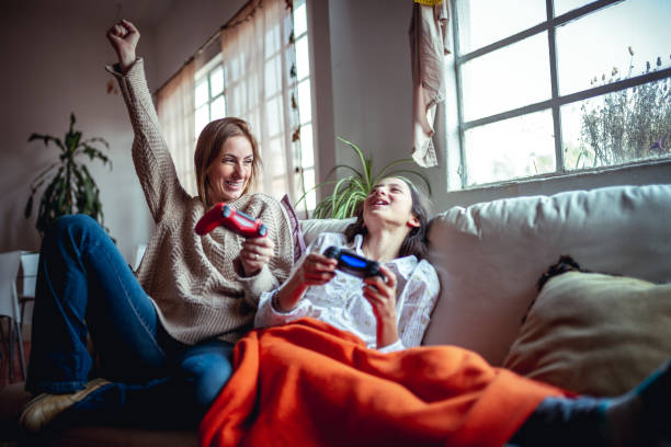 mother and daughter playing video games - childs game imagens e fotografias de stock