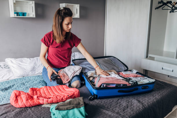 istock Young woman packing clothes 1176304542