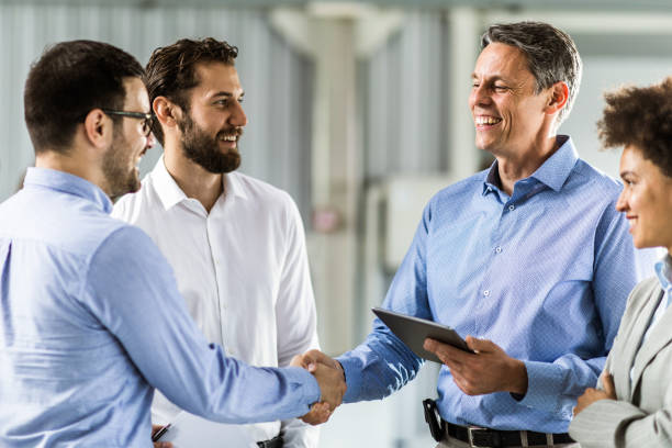 istock Happy businessmen shaking hands in a board room. 1176304568