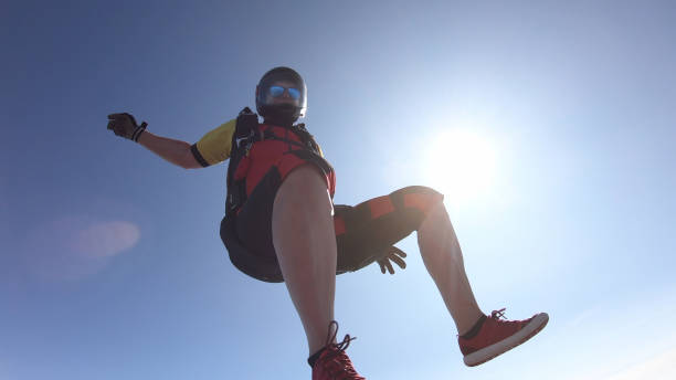 istock Skydiver falls through clear skies, in aerial flight 1176308762