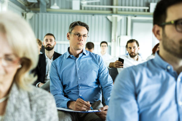 istock Mid adult businessman attending a training class in a board room. 1176308769