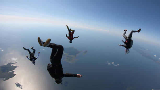 skydivers fall through clear skies, in aerial flight - activity baltic countries beauty in nature blue imagens e fotografias de stock