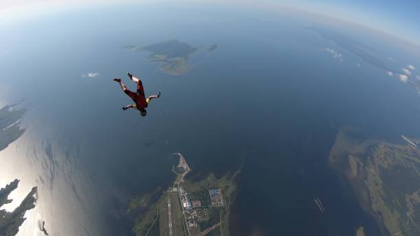 istock Skydiver falls through clear skies, in aerial flight 1176308859