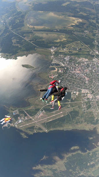 les parachutistes tombent dans un ciel clair, en vol aérien - skydiving air aerial view vertical photos et images de collection