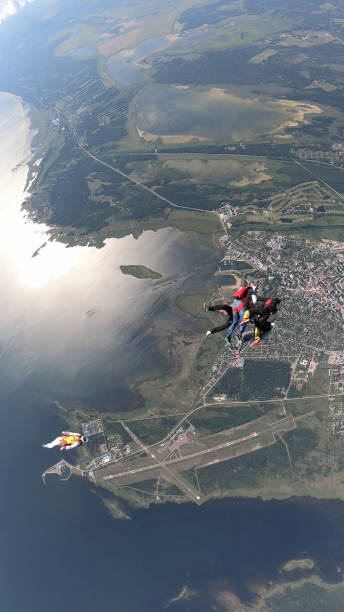 les parachutistes tombent dans un ciel clair, en vol aérien - skydiving air aerial view vertical photos et images de collection