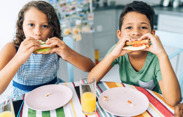 enfants mangeant des sandwichs - healthy lifestyle people eating sister photos et images de collection
