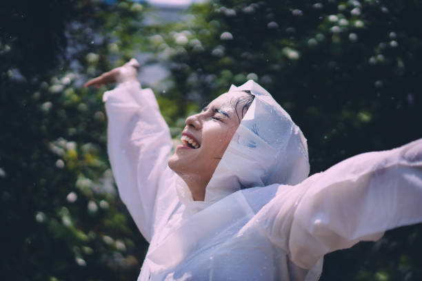 アジアの女性は雨の日に幸せです。 - umbrella women storm yellow ストックフォトと画像