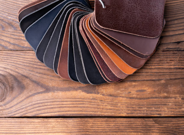 Leather samples for shoes on dark wooden table. Designer furniture clothes.