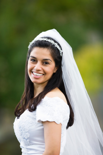 A young Hispanic bride smiling and posing for the camera.