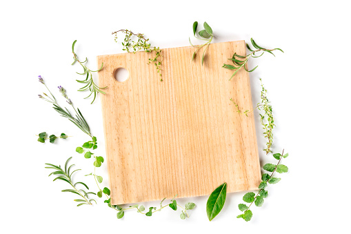 Recipe Design Template. Cutting board with herbs, shot from above on a white background with copy space