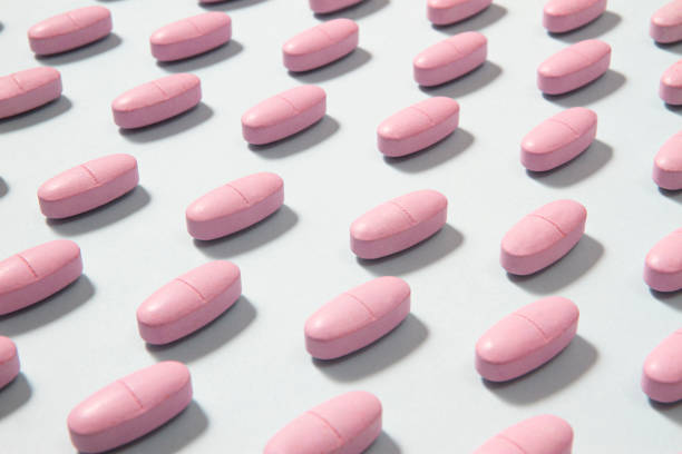 istock Pink Pills in a Row on Soft Blue Background 1176318541
