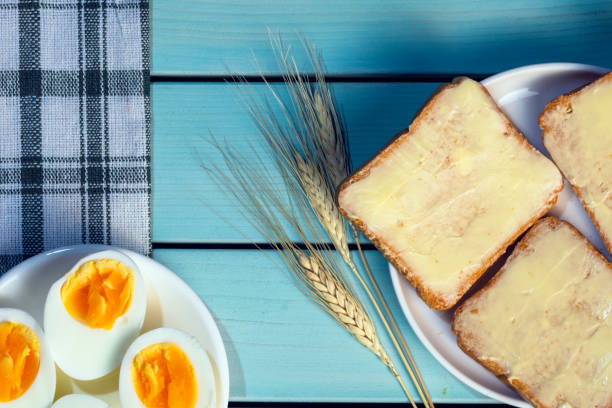 Photo of toasted bread with butter and eggs on wooden table, morning breakfast background, top view image