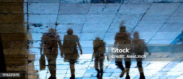 Reflection Shadow Silhouette On Wet City Sidewalk Of Mysterious People Walking Away The Night Stock Photo - Download Image Now