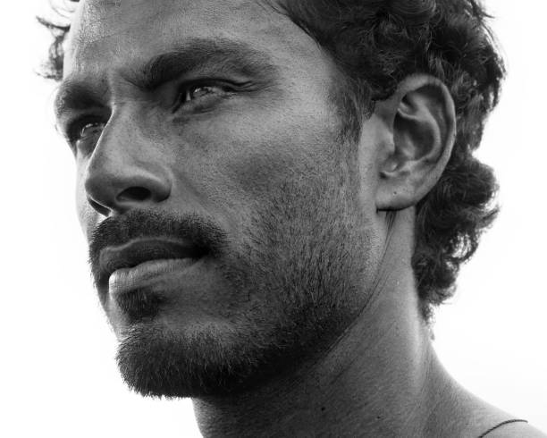 Close up portrait of healthy man with black hair, strong features, looking straight ahead at a three quarters angle, black and white stock photo