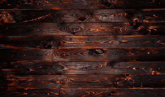 Burnt wooden board, black charcoal wood texture, burned coal barbecue background with copy space, top view