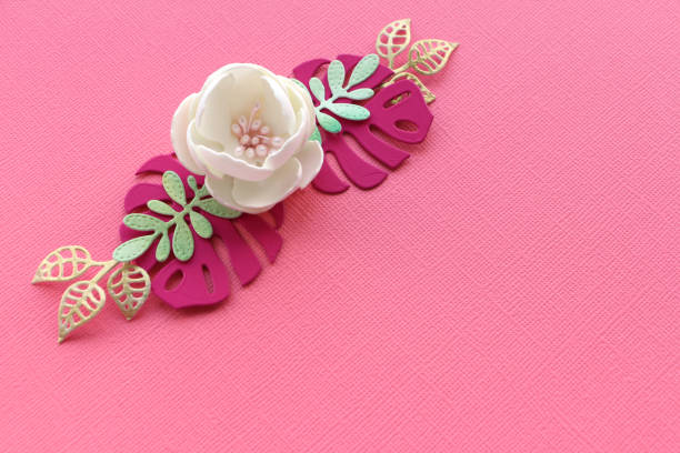 istock white handmade flower and paper leaves on a pink paper textural background. copy space. 1176321641