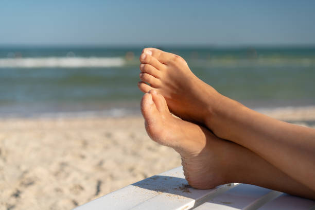 pied femelle avec le valgus d'hallux se ferment vers le haut sur la plage - misalignment photos et images de collection