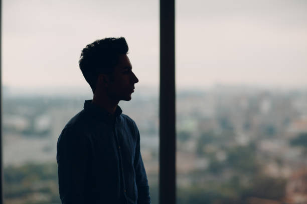 istock Young male profile portrait against window 1176324454