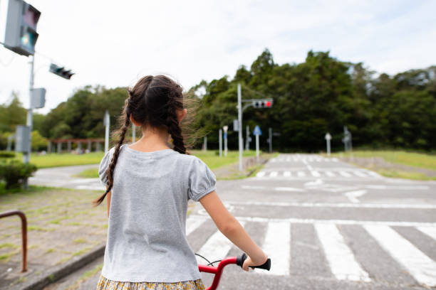 istock Girl on a bicycle stopped at a red light 1176325128