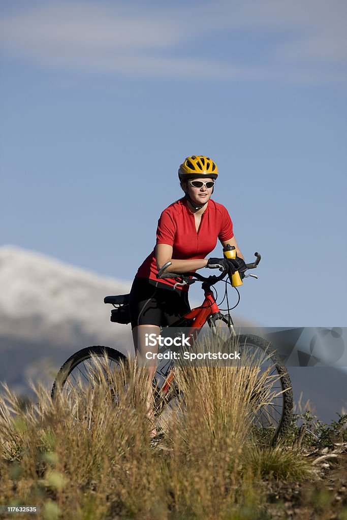 Jeune femme équitation un vélo dans les montagnes - Photo de Activité de loisirs libre de droits