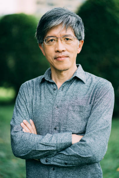 istock Asian man standing arms crossed in park 1176328007