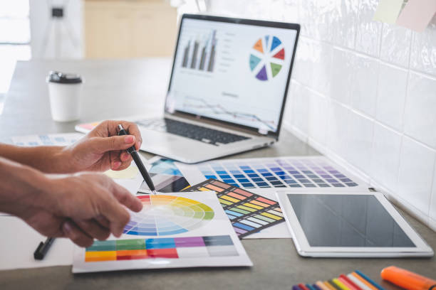 istock Teamwork of young creative designers working on project together and choose color swatch samples for selection coloring on digital graphic tablet and equipment at workplace 1176329710