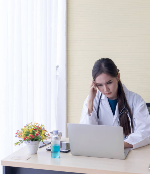 istock Asian female doctor watched A headache job in a notebook 1176331114