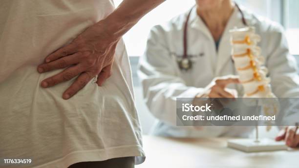 A Doctor Explaining Lumbar Anatomy To Back Pain Patient Stock Photo - Download Image Now