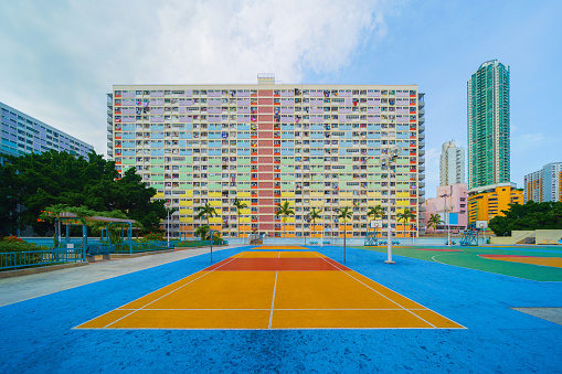 Colorful rainbow pastel building with basketball court and facade windows background in public park. Architecture building design in Choi Hung Estate, Kowloon, Hong Kong City, China.