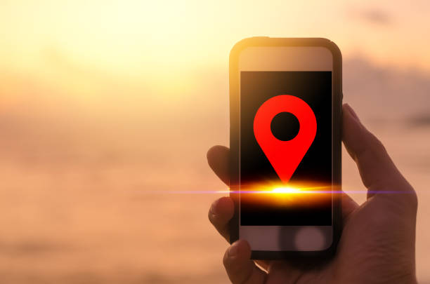 istock Copy space man hand using black smart phone on sunset beach background with navigator gps location icon. 1176335099