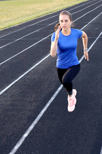 istock Runner athlete running on athletic track training her cardio in stadium. Jogging at fast pace for competition 1176335889
