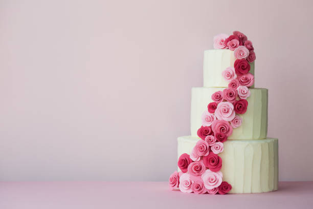 Tiered wedding cake with sugarpaste roses Tiered wedding cake with sugarpaste roses in pink wedding cake stock pictures, royalty-free photos & images