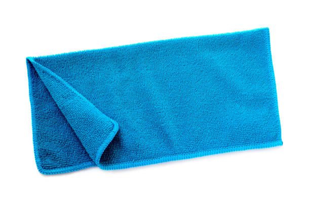 Blue beach towel on a white background with shadow. Towel isolated on a white background. Folded beach towel in blue. Summer vacation concept.