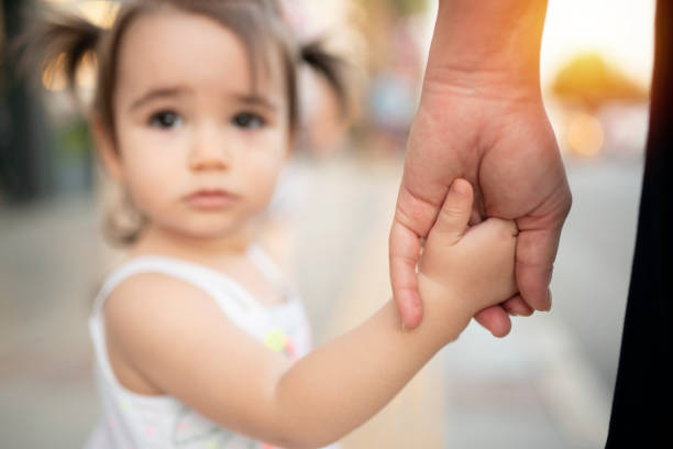 istock Mother and daughter holding hands 1176338425