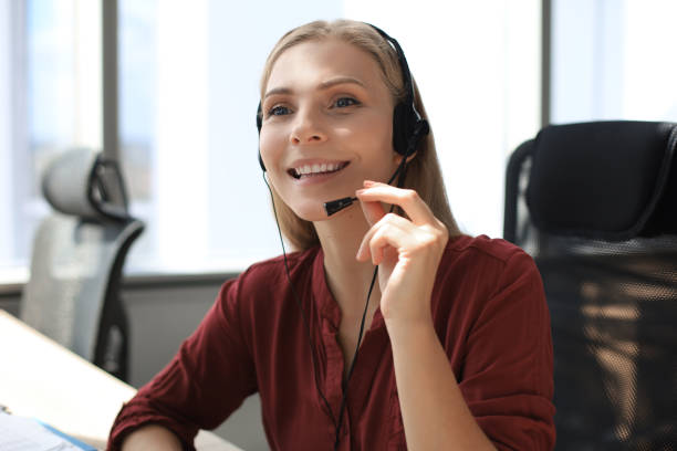 istock Beautiful smiling call center worker in headphones is working at modern office 1176339637