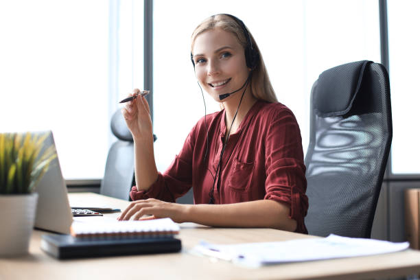 istock Beautiful smiling call center worker in headphones is working at modern office 1176340057