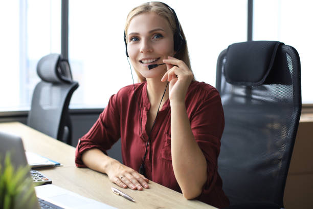 istock Beautiful call center worker in headphones is working at modern office 1176340573