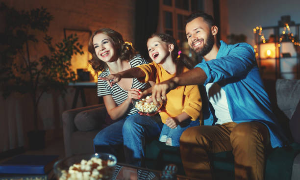 familie mutter vater und kind tochter beobachten projektor, tv, filme mit popcorn am abend zu hause - 11833 stock-fotos und bilder