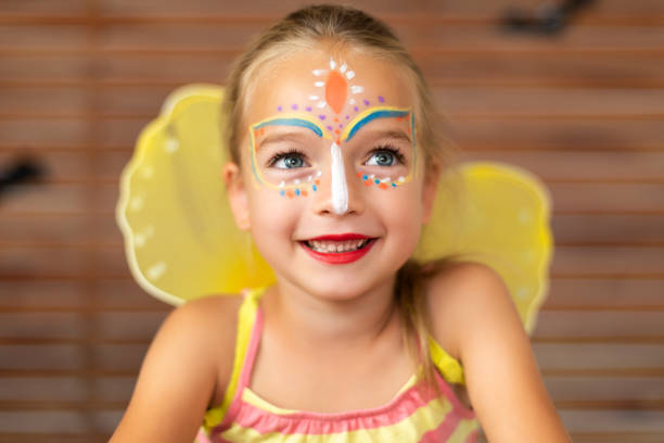 retrato de cintura arriba de preescolar lindo con pintura de la cara diy usando una mariposa halloween o traje de carnaval. - face paint human face mask carnival fotografías e imágenes de stock