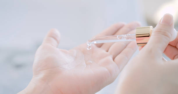 woman dropping moisturizer in hand