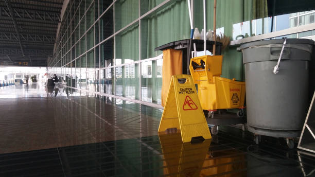 The warning signs cleaning and caution wet floor. The warning signs cleaning and caution wet floor in the building and janitorial car parked in back to remind people to walk safely. cleaning equipment stock pictures, royalty-free photos & images