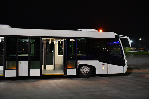 airport bus with low floor in night with open doors
