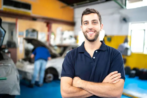 Men standing in a auto repair shop with arms crossed